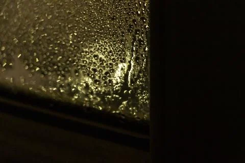 Condensation on a window pane creates a moody atmosphere, revealing soft light Stock Photos