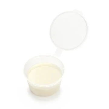Condensed milk in a plastic container isolated on a white background. Stock Photos