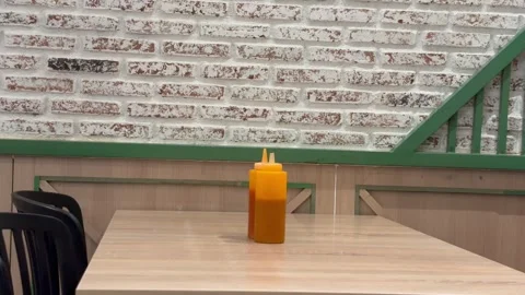 Condiment Bottles on Wooden Table in Restaurant with White Brick Wall Background Stock Footage 330144975