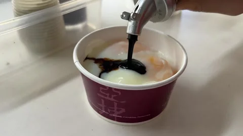 Condiments onto Soft Boiled Eggs Stock Footage 168856514