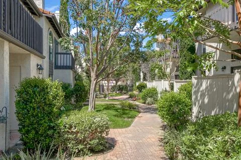 Condo complex buildings with concrete path and garden with trees in Carlsbad Stock Photos