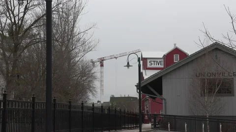 Condo construction crane rises behind old train station Stock Footage 151726855