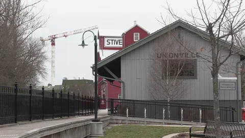 Condo construction crane rises behind old train station Stock Footage 151727279