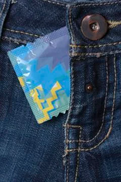 Condom in the blue jeans Stock Photos
