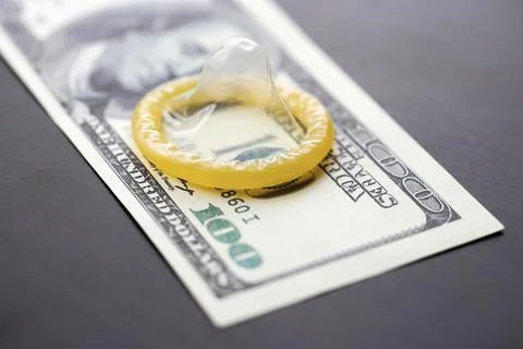 Condom on dollars bills Stock Photos