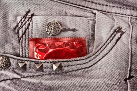 Condom in the grey jeans Stock Photos