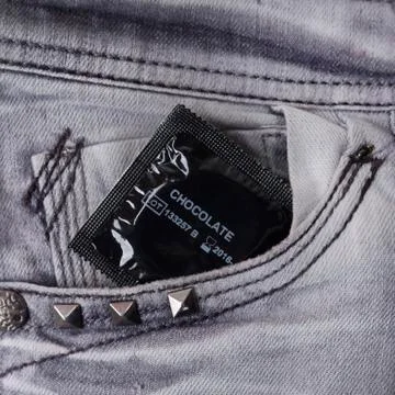 Condom in the grey jeans Stock Photos