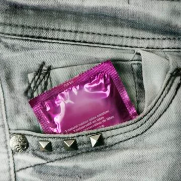 Condom in the grey jeans Stock Photos