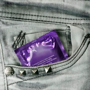 Condom in the grey jeans Stock Photos