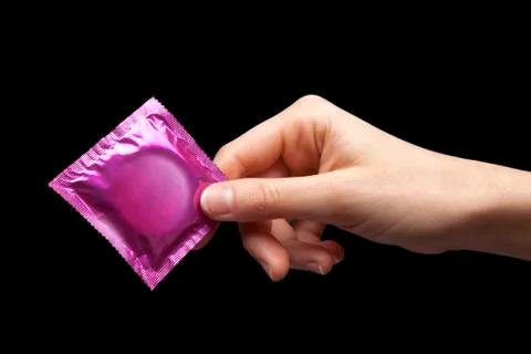 Condom in hand Stock Photos