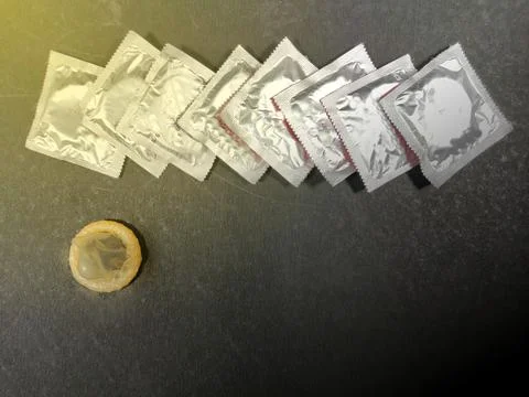 Condom a male contraception method packets on black background with space for Stock Photos