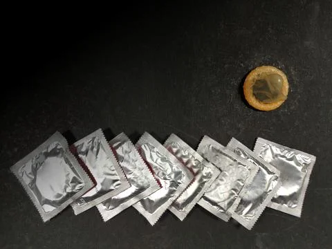 Condom a male contraception method packets on black background with space for Stock Photos