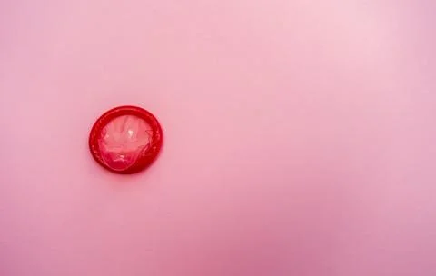 Condom on a pink background. The concept of safe sex. Stock Photos