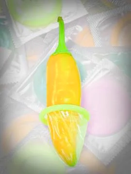 Condom on red chilli Stock Photos