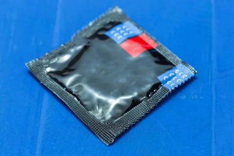 Condoms on blue background Stock Photos