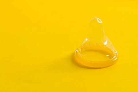 Condoms on yellow background Stock Photos