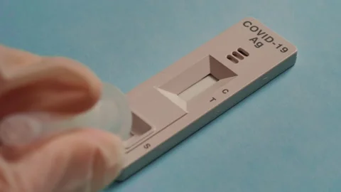 Conducting a rapid test covid-19 on a blue background Stock Footage 169891877