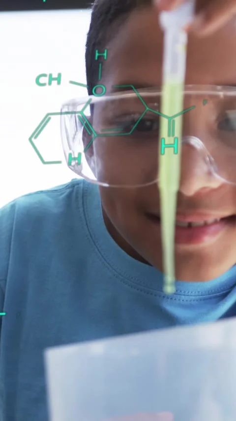 Conducting science experiment, child with safety goggles over chemical formulas Stock Footage 342704765