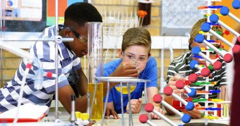 Conducting science experiment with test tubes, students in school focused and Stock Illustration