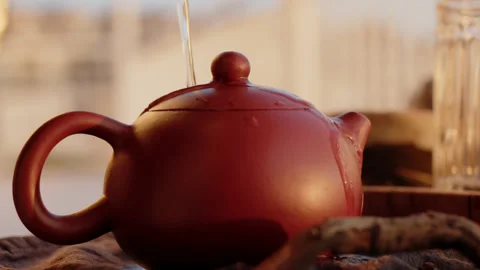 Conducting tea ceremony by tea master. Warm up ceramic clay teapot with boiling Stock Footage 222853924