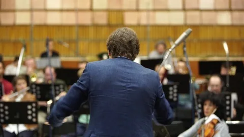 The conductor conducts an orchestra in the Studio. The view from the back Stock Footage 81707195