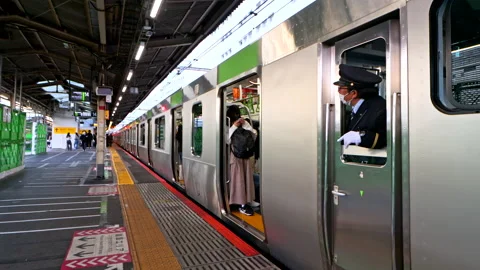 Conductor or Train Driver use hand to signal to close the door on JR Yamanote Stock-Footage 189389217