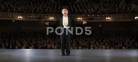 Conductor performing on stage in theater Stock Photos