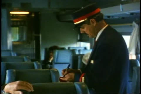 The conductor takes tickets in coach on