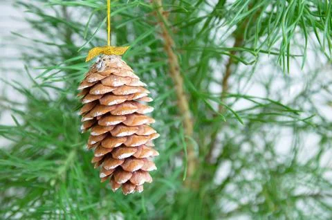 A cone with a bow close-up. Against the backdrop of a Christmas tree. 写真素材