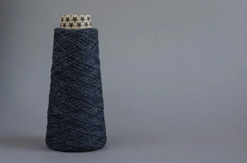Cone of gray wool yarn on light gray background. copy space Stock Photos