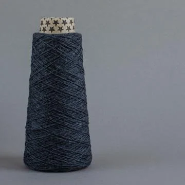 Cone of gray wool yarn on light gray background. copy space Stock Photos