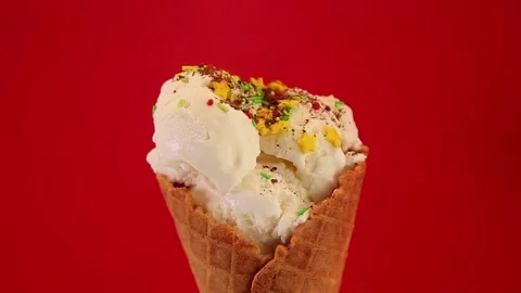 Cone with icecream on a red background is decorated with cocoa Stock Footage 163090363