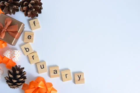 Cones and gift box on the background. The month of February is written in wooden Stock Photos