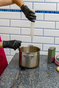 Confectioner Adding Liquid Ingredient to Hot Caramel in Commercial Kitchen Stock Photos