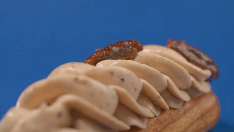 Confectioner adds pecans to the cream on eclair, cake decoration in slow motion Stock Footage 119833514