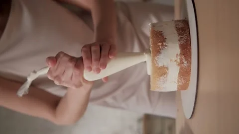 Confectioner applies the cream layer between the biscuits. Woman is cooking Stock Footage 255900837