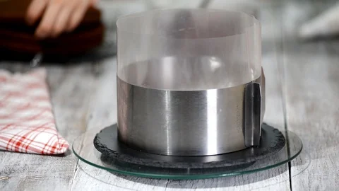 A confectioner assembles a cake in a metal round shape. Stock Footage 102374193