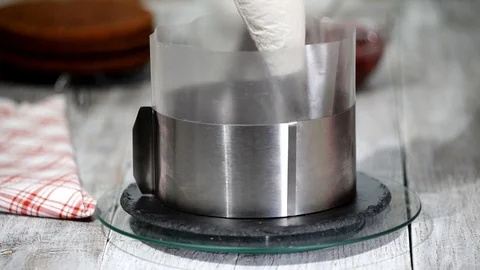 A confectioner assembles a cake in a metal round shape. Stock Footage 102431904