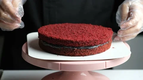 Confectioner Chef laying a red cake with black cream. Stock Footage 153689374