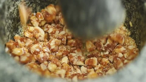 The confectioner crushing hazelnut croquant in a stone mortar. Stock Footage 171186287