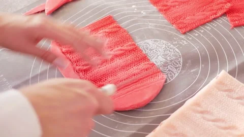 Confectioner Decorates cake with red mastic in form of knitted pattern. Home Stock Footage 165836260