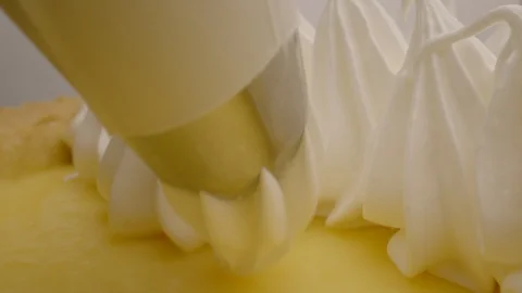A confectioner decorates a lemon tart with a syringe and nozzle. Stock Footage