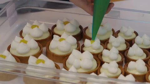 Confectioner decorating bisquits with orange jam close up shot. Stock Footage 304317239