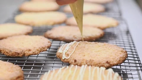 Confectioner decorating coconut biscuits with white chocolate. 스톡 동영상 157539533