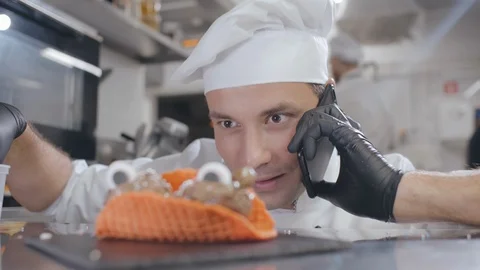 Confectioner decorating dessert and having phone call Stock Footage 125051453