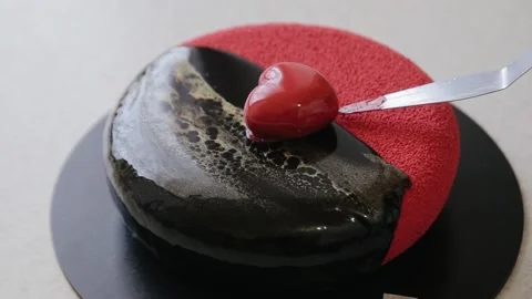 Confectioner decorating velour coating cake with heart-shaped mousse cake Stock Footage 134681266