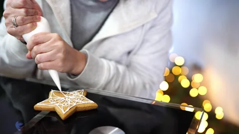 Confectioner draws icing patterns with pastry bag on Christmas cookies Stock Footage 255083787