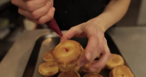 The confectioner fills the eclair with cream using a pastry syringe. Stock Footage 254816259
