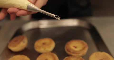 The confectioner fills the eclair with cream using a pastry syringe. Stock Footage 254816370
