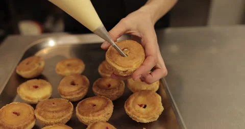 The confectioner fills the eclair with cream using a pastry syringe. Stock Footage 254817099